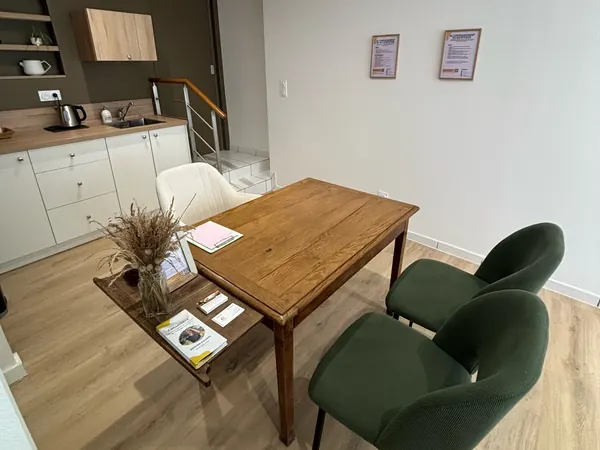La même salle sous un autre angle, avec la kitchenette et l'escalier